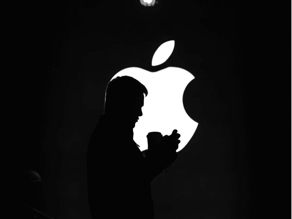 Apple logo sort baggrund mand sidder foran logoet